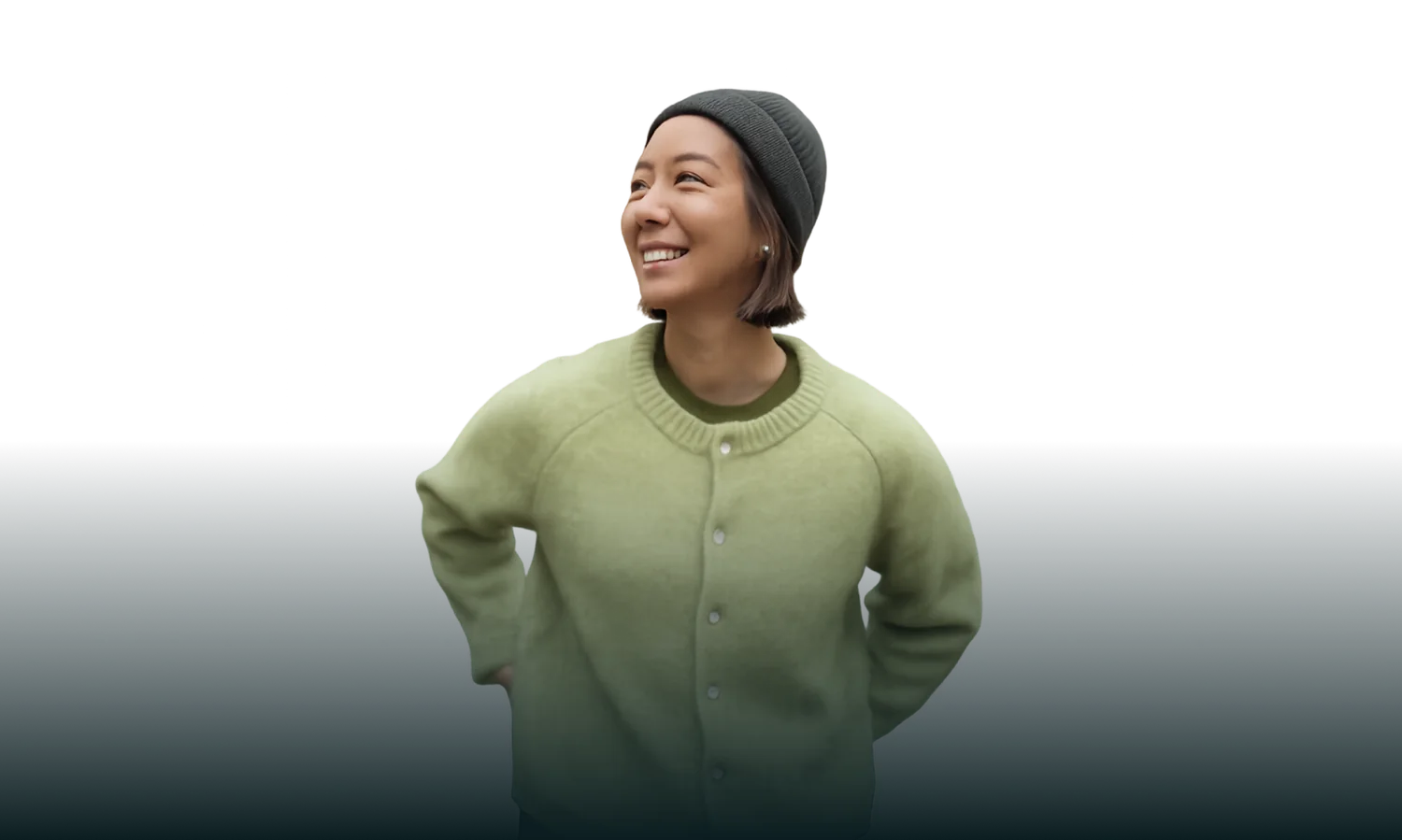 Smiling woman in a green sweater and beanie